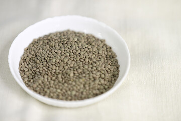 Bowl of Raw Lentils on Natural Fabric Background
