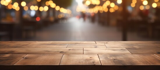 A hardwood table stands in the foreground with a blurred background featuring a mix of buildings and road surfaces. The wood is stained with a rich shade, adding character to the room - obrazy, fototapety, plakaty