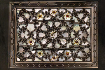 Turkish Islamic art of mother-of-pearl inlay with dark geometrics and jewel accents.