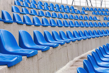 Plastic blue seats on street auditorium or stadium. No people, side view, perspective