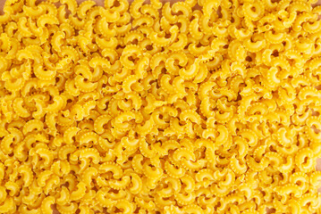 Background of Italian pasta Creste Di Gallo dry, raw pasta. Rooster scallop. Top view.