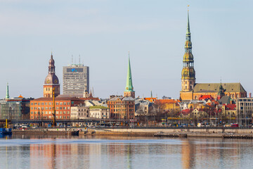 Fototapeta premium Riga towers and rooftops day time skyline. Sunny spring time shade on the buildings in Riga, next to a market and new project of railway in the Baltic States