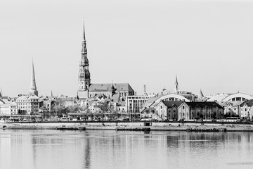 Naklejka premium Riga panoramic view of towers, old town and market with reflection of the city in the mirror surface of river