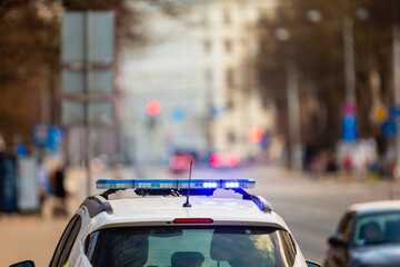 Law enforcement car with turned on police lights stoped the traffic to ensure public safety in...