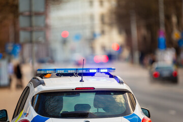 Law enforcement car with turned on police lights stoped the traffic to ensure public safety in...