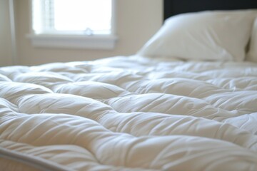 A bed with a white comforter and pillows