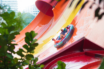 Kids on water slide. Family in aqua theme park.