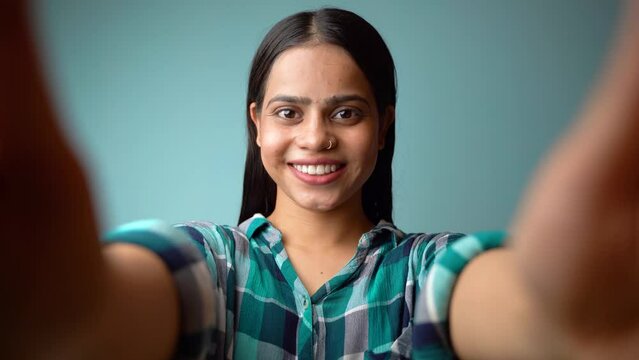 Young woman taking selfie portrait, POV shot of a beautiful Asian Indian girl taking her picture