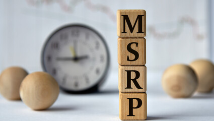MSRP - acronym on wooden cubes on graph, clock and wooden balls background.