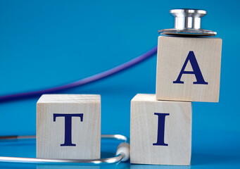 TIA - acronym on wooden large cubes on blue background with stethoscope