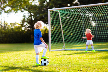 Kids play football. Child at soccer field.