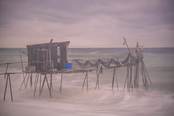 wooden fishing piers lying on the sea of Marmara cloudy weather sunset hours while the waves hit...