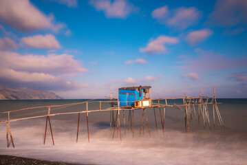 wooden fishing piers lying on the sea of Marmara cloudy weather sunset hours while the waves hit...