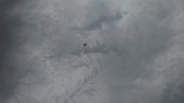 An aeroplane flying under dark clouds, an overcast sky, weather alert , Airbus A380