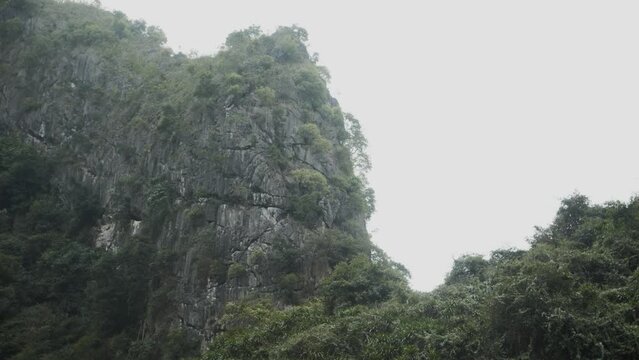 Stunning and stable landscape shot wrapping around cliffs in Ha Long Bay Vietnam