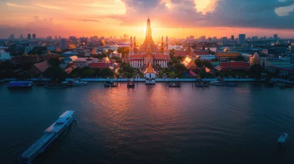  A panoramic view of Wat Arun temple at sunset in Bangkok, Thailand with the river and city in the background © Kien