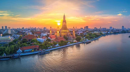  A panoramic view of Wat Arun temple at sunset in Bangkok, Thailand with the river and city in the background © Kien