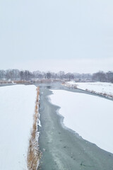 River Flowing Through Snow-Covered Field - 766945738