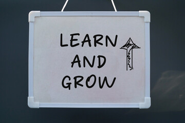 Learn and grow concept on stick note. Word concept Learn and grow on blackboard with nature background