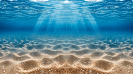Fototapeta na wymiar Underwater scene view of sandy sea bottom and the sunbeams over the coral reef.