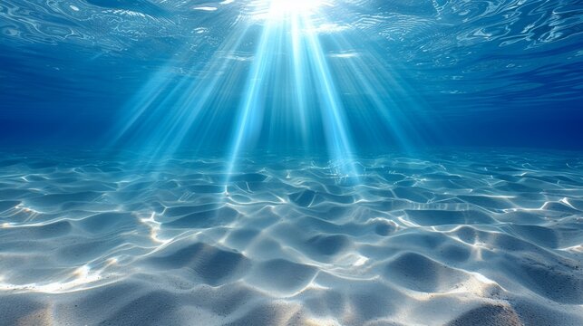 Underwater scene view of sandy sea bottom and the sunbeams over the coral reef.