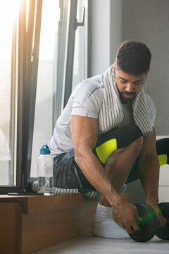 Active black man sets up the weights for the next exercise at home