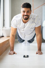 Smiling black man workout at home and doing push ups