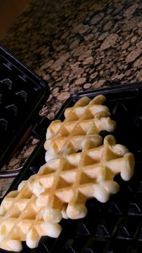 Viennese Belgian waffles corrugated. The process of baking in an electric waffle iron. Cooking. High quality 4k footage