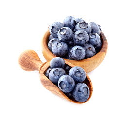 Fresh ripe berry in closeup. Black berries. Blueberries in wooden spoon on white background.