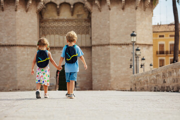 Boy and girl walk in front of famous Torres de Serranos gate