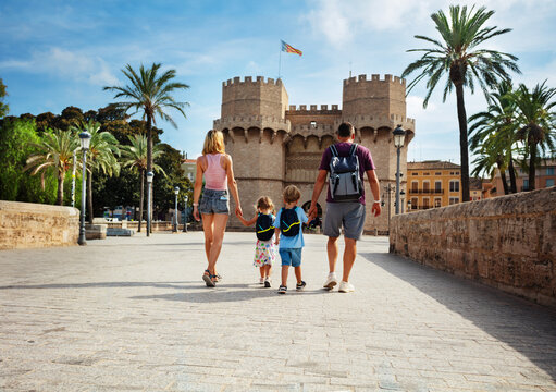 Parents with kids walk in front of famous Torres de Serrans