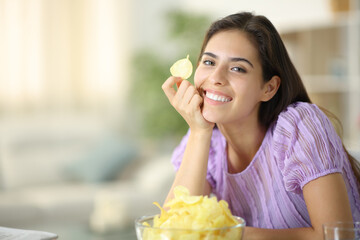 Happy woman posing holding potato chip