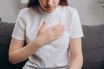 Acid reflux disease. Sad young female have symptom gastroesophageal, esophageal, stomach ache and heartburn pain hand on chest from digestion problem after eat food. Healthcare medical concept