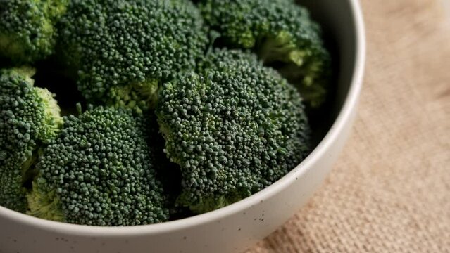 Fresh vegetable broccoli in kitchen bowl with rough burlap. Green texture of crucifers plant. Healthy lifestyle. Rotation