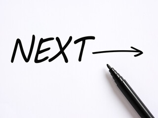 The word NEXT handwritten on white background. Next level or step in business or education concept.
