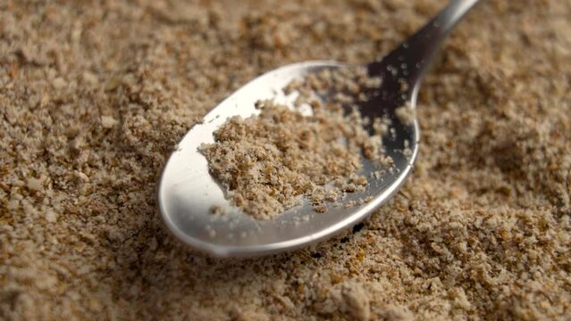 Silymarin powder supplements with ground Milk Thistle seeds in measuring spoon for liver health. Alternative herbal medicine ingredient. Rotation