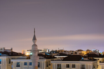 Mosque minaret in the foreground and residential rooftops in the background. a mosque in istanbul....