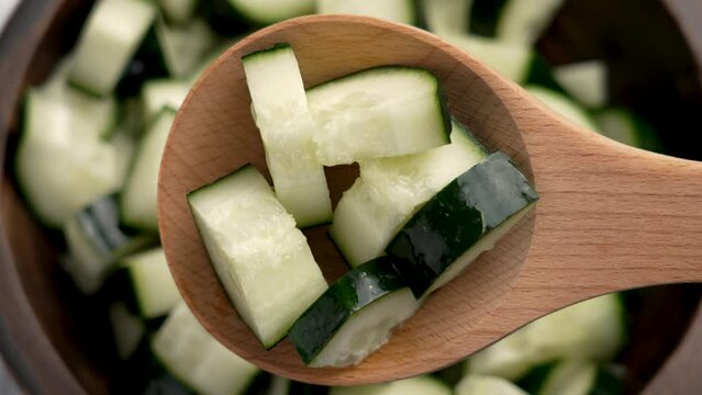 resh green cucumber slices in wooden spoon close up. Healthy vegetable organic salad ingredients