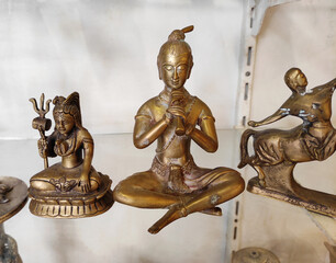 Fototapeta na wymiar Decorative metal figurines of Buddha in a meditative pose on a shop window
