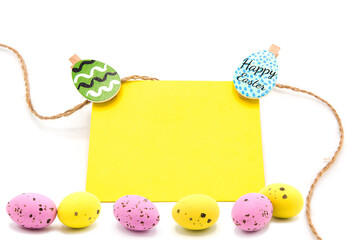 Greeting blank card with rope on clothespins with scattered colored eggs isolated on a white background. Copy space. Free space for text. Happy easter!	
