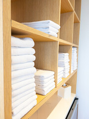 Fototapeta na wymiar Neatly Stacked Towels on Wooden Shelves Display