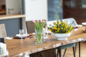 a vase with flowers on the dining table is a festive setting