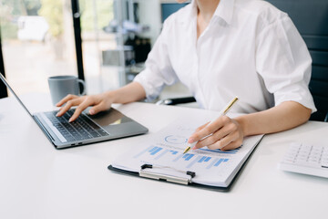 Confident businesswoman working on laptop,tablet and smartphone at her workplace at office...