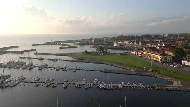 Marina in Simrishamn, Sweden at sunrise. Backward reveal drone shot.