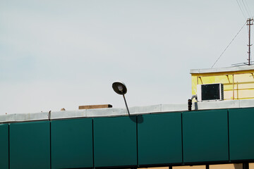 white modern energy-saving electric lighting street lamp on the background of the city building wall on a cloudy summer day