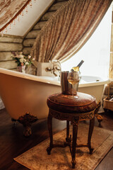 Close-up of a glass of wine and a bottle in an ice bucket on an elegant chair in the bathroom