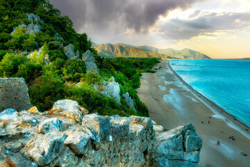 top view of the rocky Mediterranean coastline, beautiful beach and green mountains.