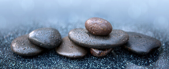 Black spa stones on the gray table background.