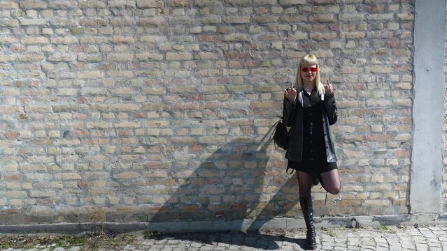 Young beautiful strong independent rebel blonde woman Punk music and style fan posing. Confident Punk-Rock youth culture street style concept. Cool attitude bee different concept