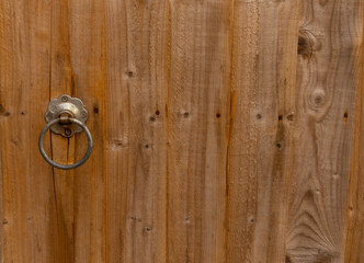 round metallic handle on wooden gate. natural background